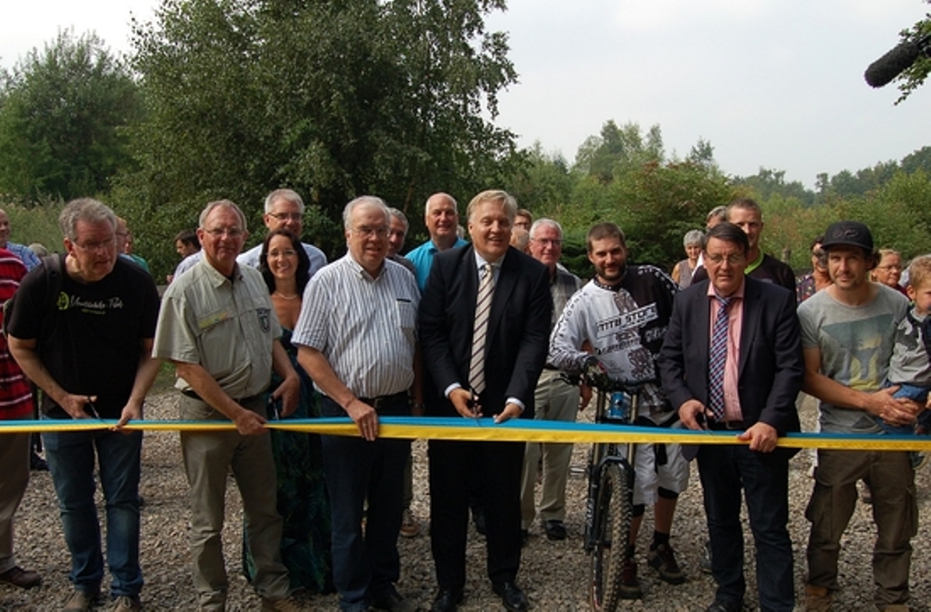 Klaus Wißmann, Günther Hieke, Landrat Wolfgang Spelthahn und Bürgermeister Axel Buch (v.l.) gaben den Bike-Park offiziell für den Betrieb frei. Raoul Sous stand für den rasanten Ritt ins Kalltal bereit. 