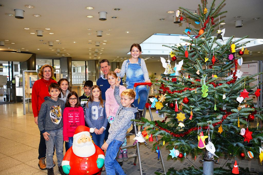 Hans-Jörg Feltes, Leiter des Bürgerbüros, Barbar Scholl und die Kinder der Klassen 4a und 4b der KGS LeNie sind zu Recht stolz auf ihre Weihnachtsbaumdekoration.