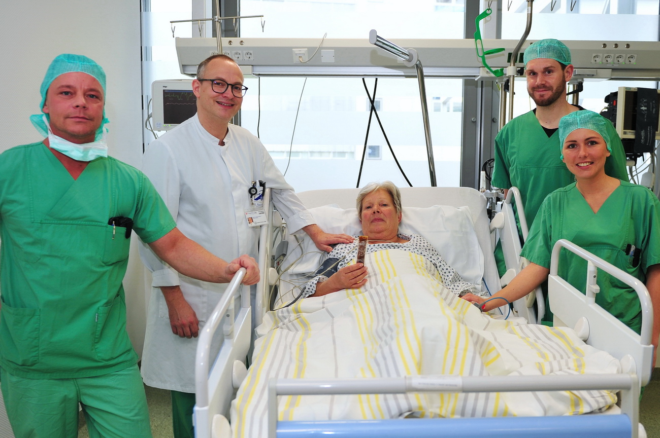 Foto (© K. Erdem): Patientin Monika Abschlag (Bildmitte) genießt ihr Eis nach der OP. Dabei sind v.l. Dieter Thöne (Leitender Fachpfleger der Anästhesie), Dr. med. Markus Huppertz-Thyssen (Chefarzt der Klinik für Anästhesiologie), Stefan Wachs (Anästhesie-Pflegekraft) und Mona Hamacher (Anästhesie-Fachschwester)