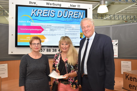 Landrat Wolfgang Spelthahn, Amtsleiterin Elke Baum-Teschner (l.) und die Kundin Petra Becker freuen sich, dass das Straßenverkehrsamt des Kreises Düren Privatkunden die Reservierung von Terminen anbietet, um Wartezeiten zu vermeiden. Foto: Kreis Düren 