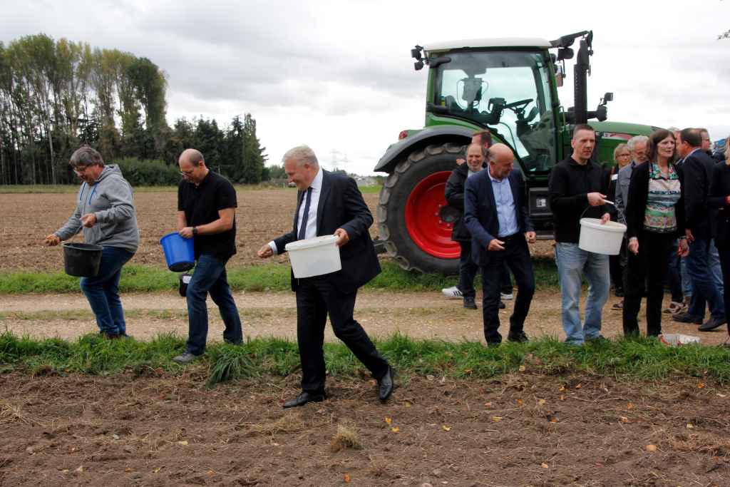  Landrat Wolfgang Spelthahn verteilt auf einem Feldstreifen am Rande von Ellen in der Gemeinde Niederzier Saatgut. Im nächsten Frühjahr werden hier Wildblumen blühen.