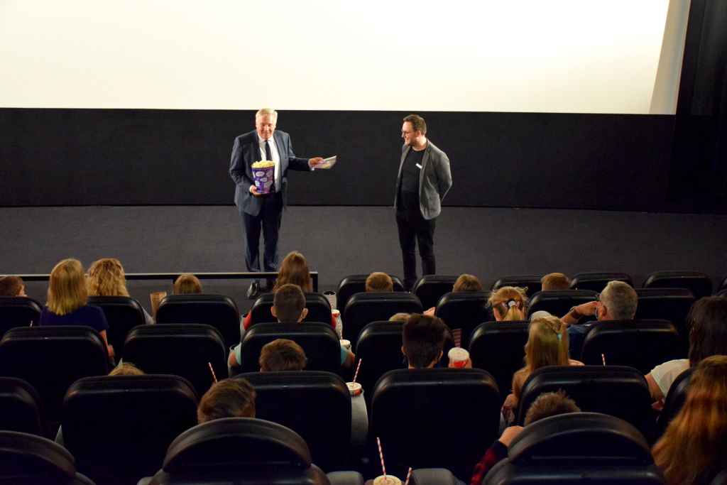 Landrat Wolfgang Spelthahn überreichte den Betreuern der Kinder- und Jugendheime des Kreises Düren Kino- und Snackgutscheine für das Lumen-Filmtheater Düren für alle Kinder und Jugendlichen. Unterstützt wird die Ferien-Aktion von Kino-Betreiber Benjamin Riedel (stehend rechts). Foto: Kreis Düren