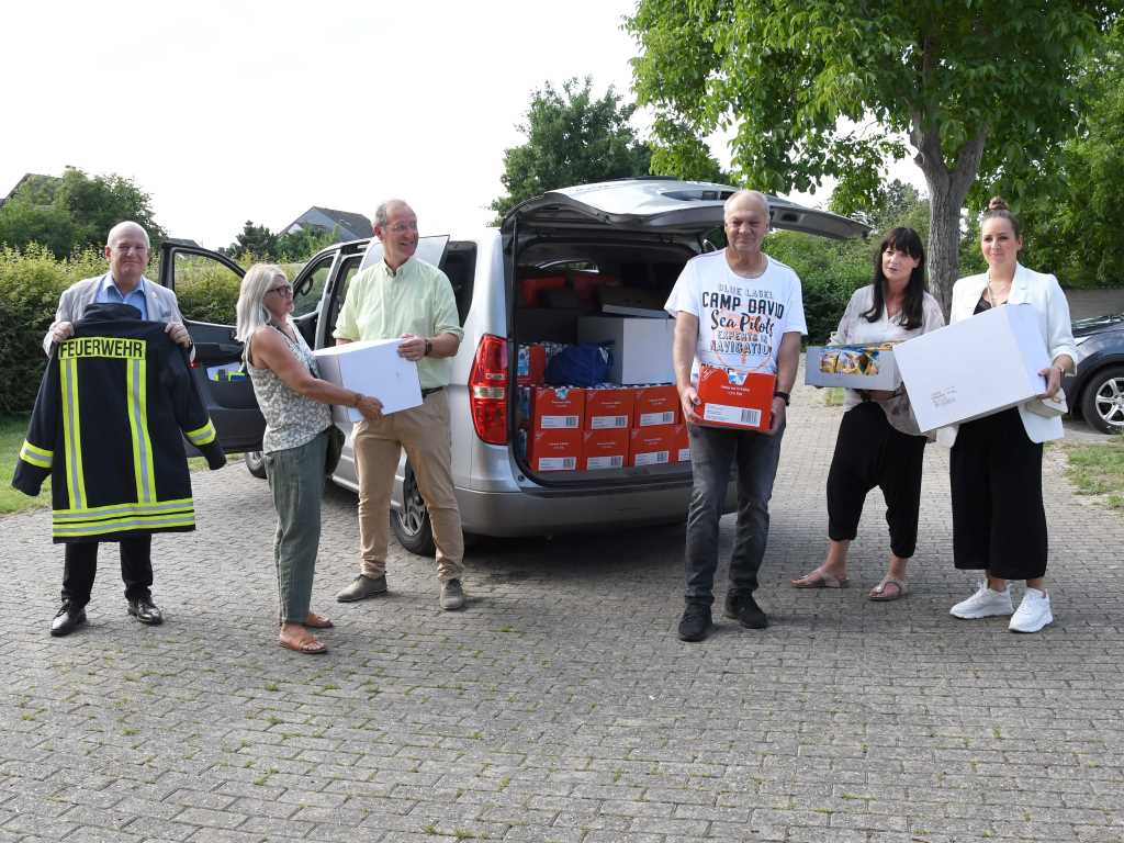 Mit einem vollgepackten Transporter, der mit Geld aus dem von der Stadt Düren eingerichteten Spendenkonto zur Ukraine-Hilfe und dem Erlös des Ukraine-Benefizkonzerts im Mai angeschafft werden konnte, ist der Dürener Gastronom Gerhard Suhr (3.v.r.) zusammen mit seiner Frau, Anke (2.v.r.), zu einem weiteren Hilfstransport nach Stryj aufgebrochen. Bürgermeister Frank Peter Ullrich (l.) gab den beiden eine Uniform der Feuerwehr Düren mit auf den Weg. Die ist für den Feuerwehrchef in Stryj gedacht. 