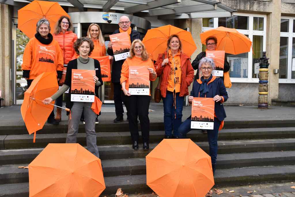 Setzen am Internationalen Tag gegen Gewalt an Frauen ein sichtbares Zeichen: Die Gleichstellungsbeauftragten Katja Muhl (Stadt Düren), Andrea Kenter (Kreises Düren), Monika Paillon (Gemeinde Kreuzau, vorne v.l.) sowie Marie Brenner (Beratungsstelle für Frauen und Mädchen Kreis Düren), Jennifer Dohm (Gleichstellungsbeauftragte der Stadt Linnich), Jessica Fischer (Gleichstellungsbeauftragte der Stadt Jülich), Peter Kaptain (Allgemeiner Vertreter des Landrats), Sigrid Bergsch, Klaudia Jäger (beide HObAS e.V., hinten v.l.). Foto: Kreis Düren