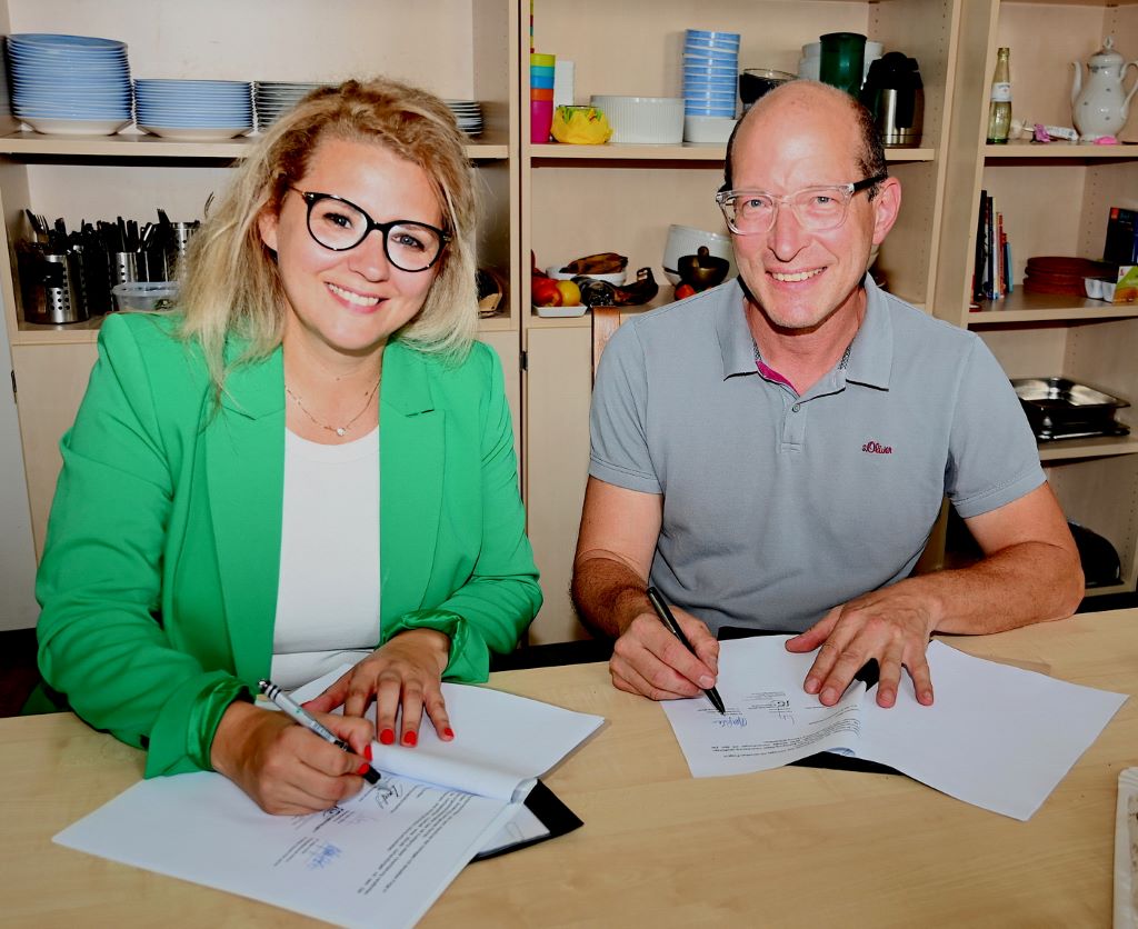 (© Tatjana Opgenorth): Nadja Haupt, Schulleiterin der Sekundarschule Jülich und neue Kooperationspartnerin der Jugendhilfe „extraKlasse“, und Dr. Stefan Grothe, Chefarzt der Sozialpädiatrie am St. Marien-Hospital Düren, unterzeichnen den Kooperationsvertrag.