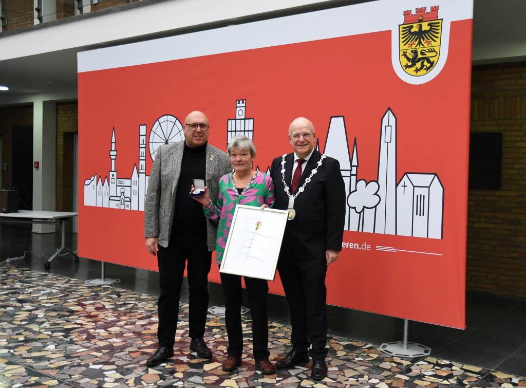 Foto: (v.l.) Dirk Nieveler und Verena Schloemer bei der Überreichung der Bürgermedaillen und Urkunden durch Bürgermeister Frank Peter Ullrich.
