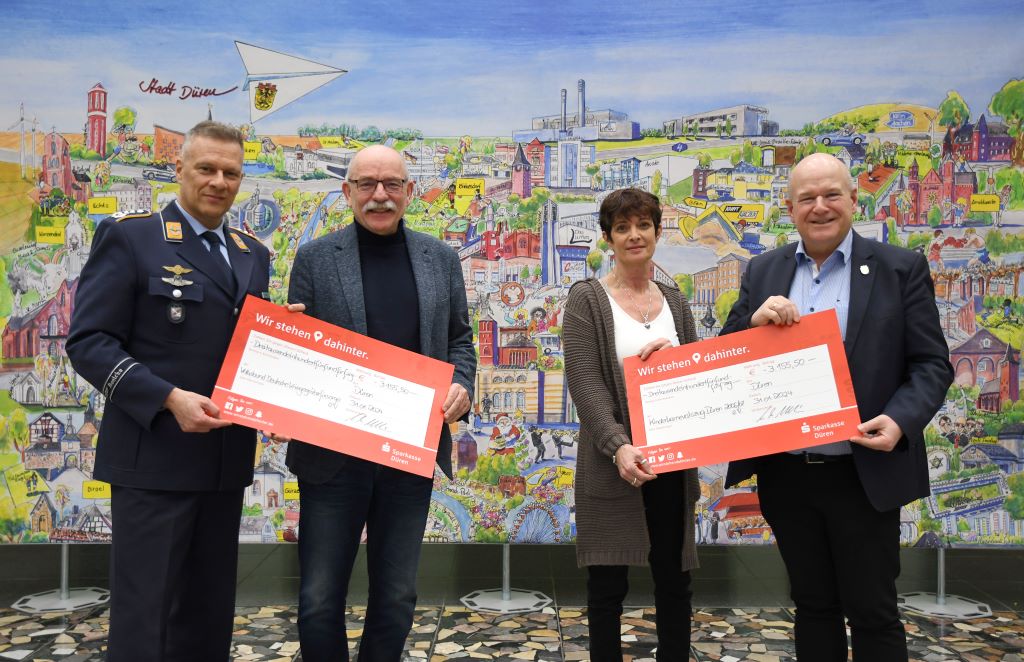 Foto: (v.l.n.r.) Oberst Timo Heimbach, Peter Kaptain, Monika Leßenich und Bürgermeister Frank Peter Ullrich bei der symbolischen Scheckübergabe im Dürener Rathaus.