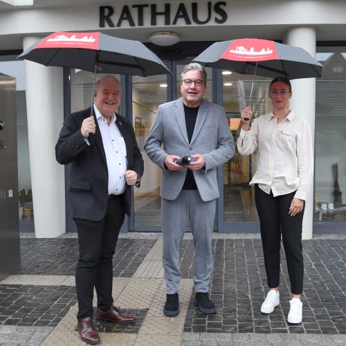 Foto: (v.l.n.r.) Bürgermeister Frank Peter Ullrich, Uwe Willner, Vorstandsvorsitzender der Sparkasse Düren und Nina Grüber von der Repräsentation der Stadt Düren präsentieren die neuen Taschenschirme der Stadt Düren.