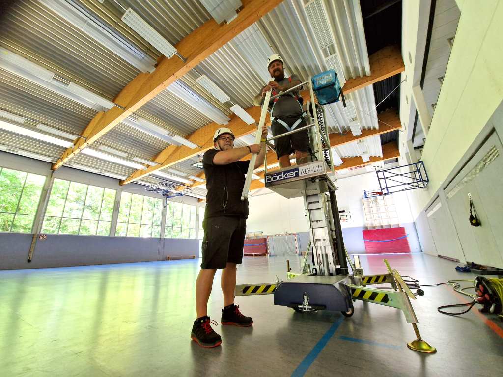 Guido Floßdorf (li.) und Jens Knipprath hier bei der Umrüstung der Beleuchtung in der Sporthalle der Anne-Frank-Gesamtschule.