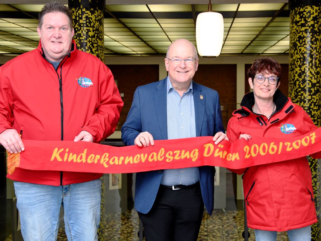 Frank Leßenich (l.), Monika Leßenich (r.) vom Verein „Kinderkarnevalszug Düren 2006/2007 e.V.“ und Bürgermeister Frank Peter Ullrich freuen sich auf den 17. Dürener Kinderkarnevalszug am 26. Januar 2025.
