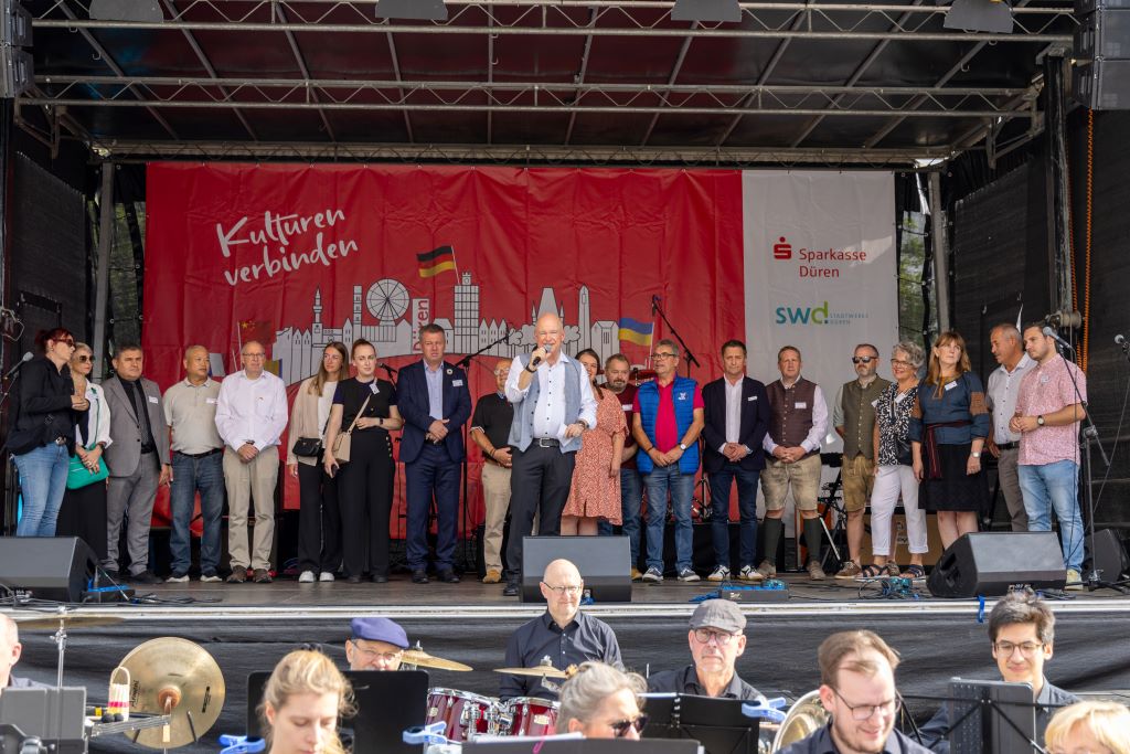 Zur Eröffnung der Partnerschaftsmeile der Stadt Düren begrüßte Bürgermeister Frank Peter Ullrich Vertreterinnen und Vertreter der Delegationen aller sieben Partnerstädte auf der Bühne auf dem Kaiserplatz.
