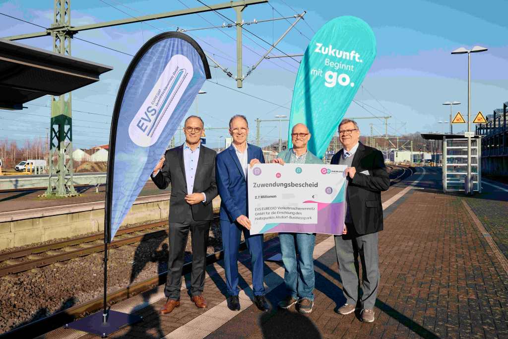 Bild: go.Rheinland GmbH Es zeigt die Geschäftsführer der EVS EUREGIO Verkehrsschienennetz GmbH, Thomas Fürpeil (l.) und Christian Hartrampf (r.), mit go.Rheinland-Geschäftsführer Dr. Norbert Reinkober (2. v. l.) und Guido Trösser-Berg, Bereichsleiter SPNV-Investitionsförderung und Infrastrukturentwicklung bei go.Rheinland, bei der Übergabe des symbolischen Förderschecks.