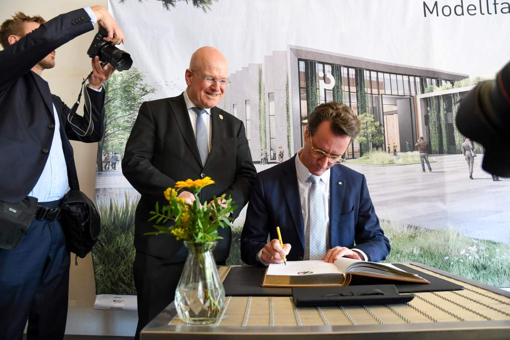 Im Beisein von Bürgermeister Frank Peter Ullrich (li.) trägt sich Ministerpräsident Hendrik Wüst in das Goldene Buch der Stadt Düren ein.
